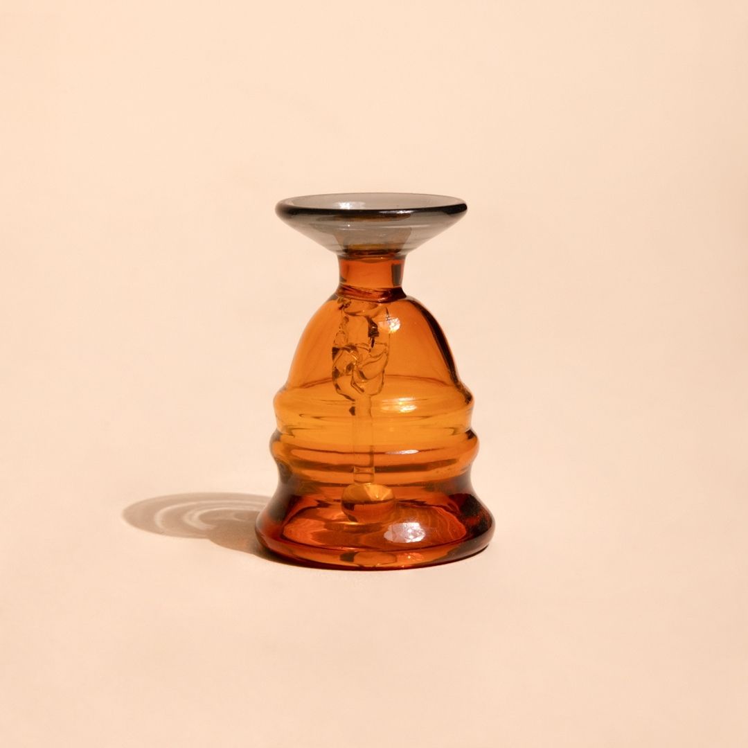 Short amber glass puja bell, studio view