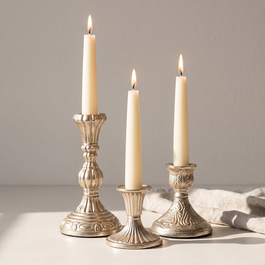 Embossed taper candle holders with lit candles