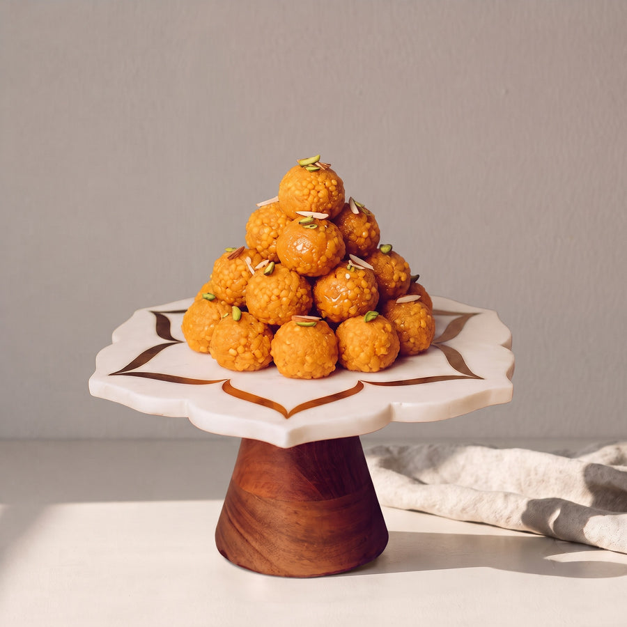 Marble cake stand piled with laddoos
