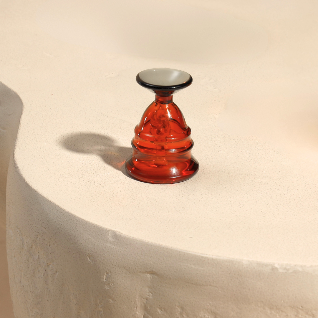 Short amber glass puja bell with slate-grey handle