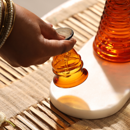 Ringing the amber glass bell beside a glass diya