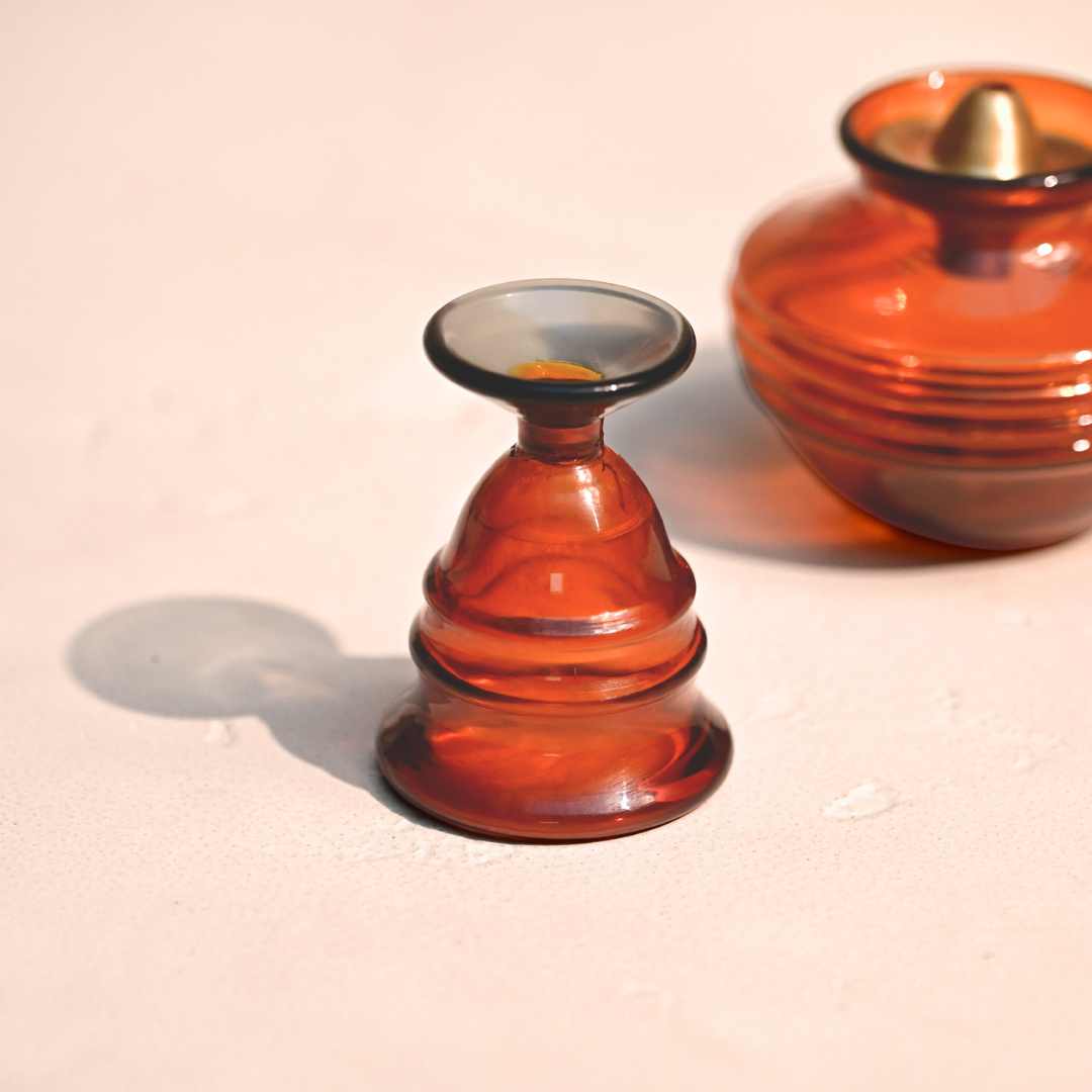 Amber glass bell next to an amber glass kalash