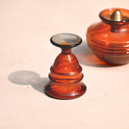Amber glass bell next to an amber glass kalash