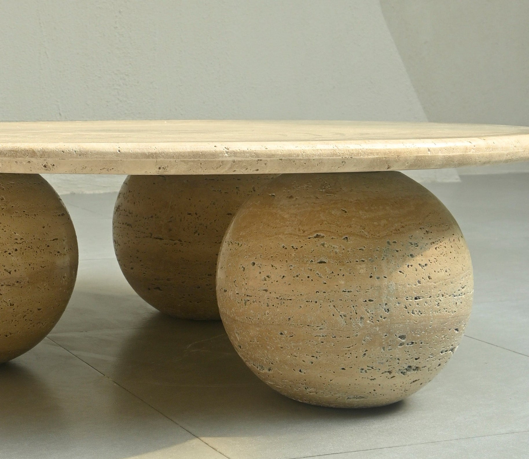 Modern coffee table with round stone-like bases on a neutral background
