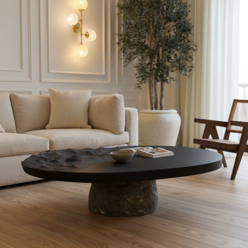 Modern living room with a black coffee table, beige sofa, and decorative plant.