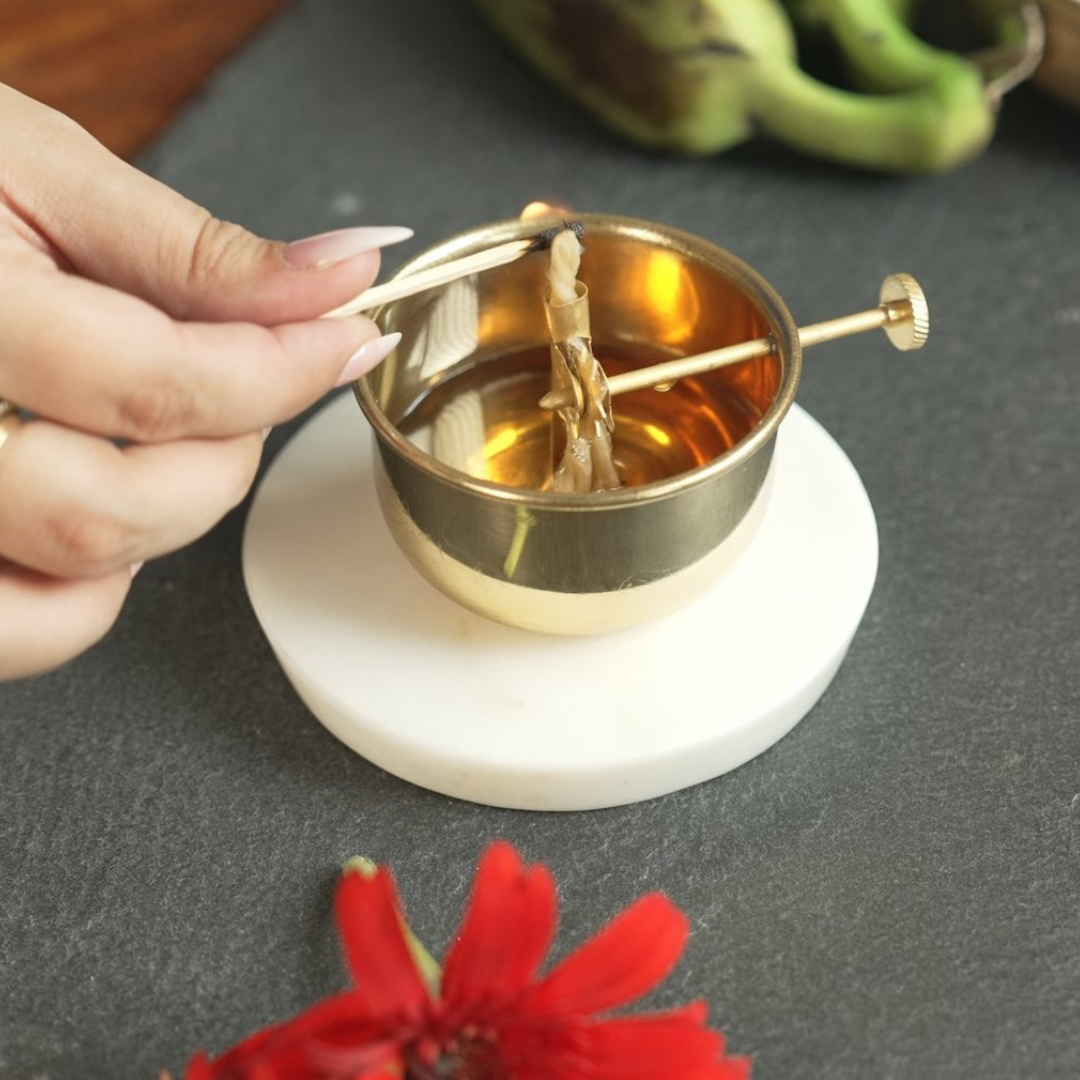 Placing the cotton wick in the brass diya