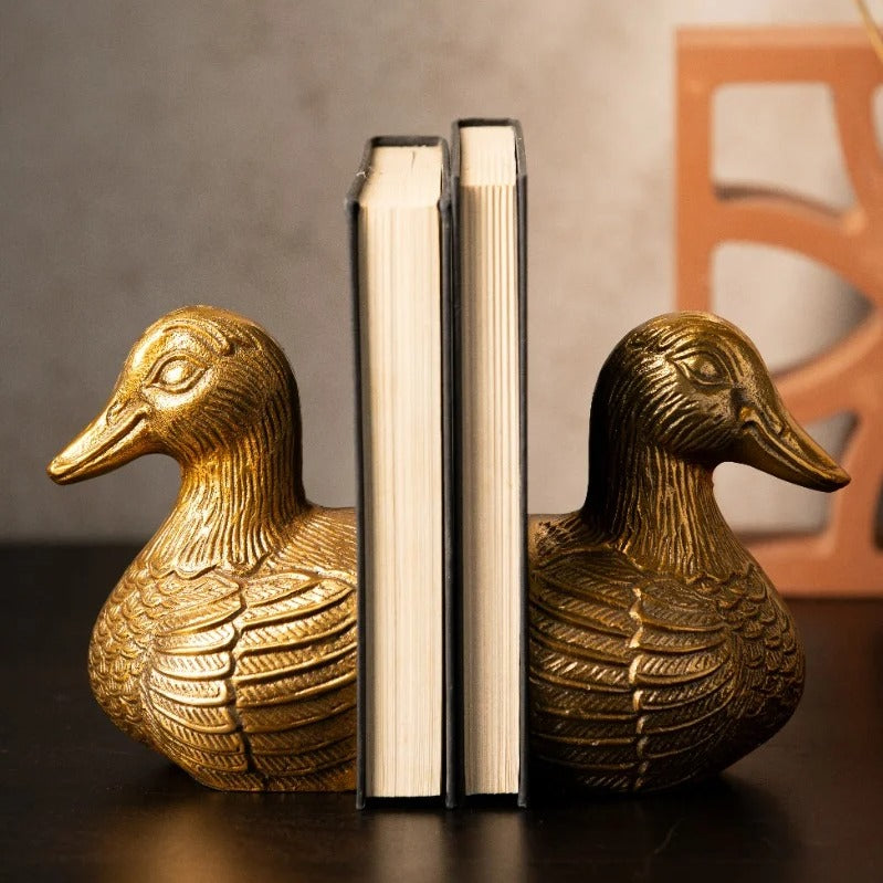 Antique gold duck bookends holding books