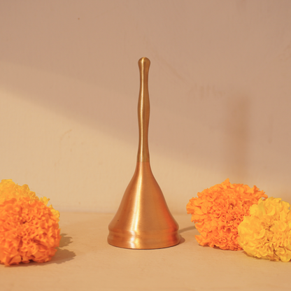 Brass and copper puja bell with marigold flowers