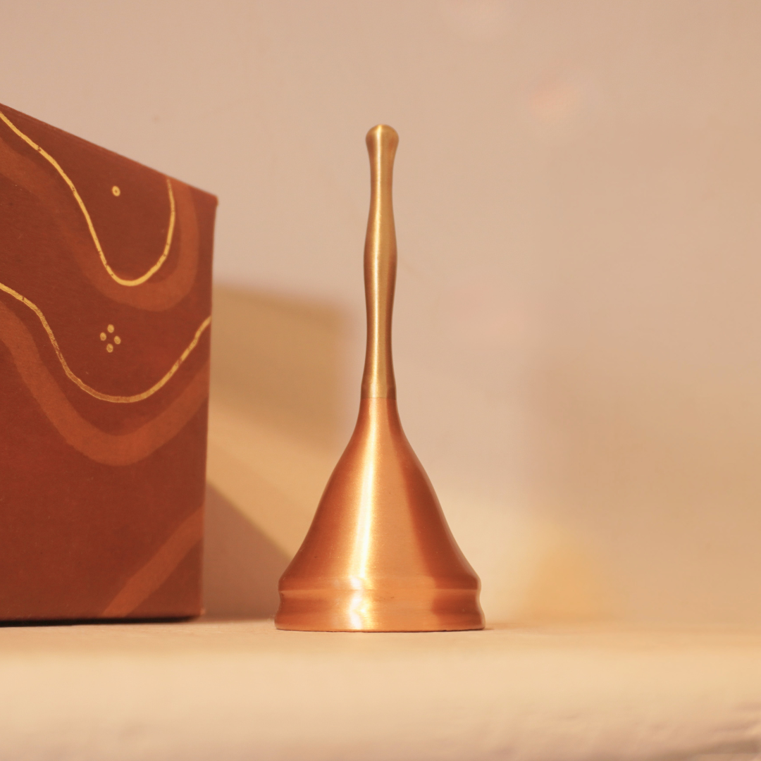 Brass and copper puja bell beside its gift box