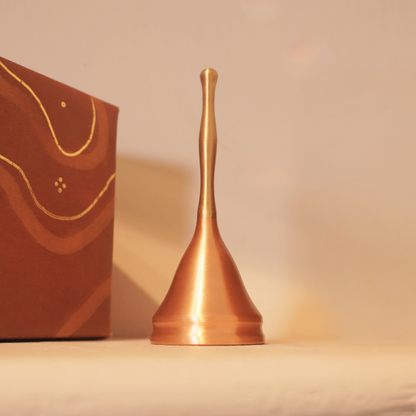 Brass and copper puja bell beside its gift box