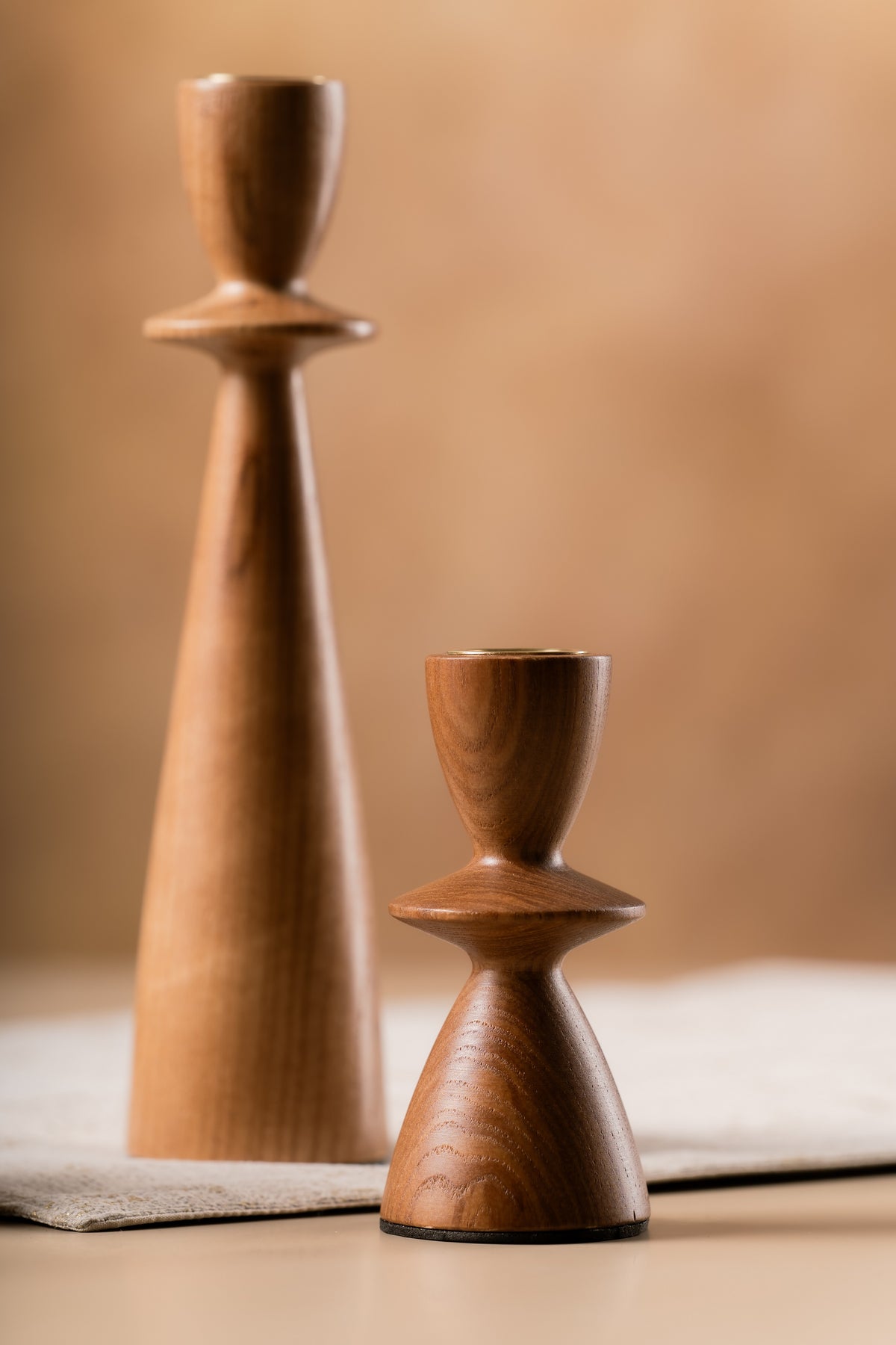 Sculptural wooden candle holders side by side