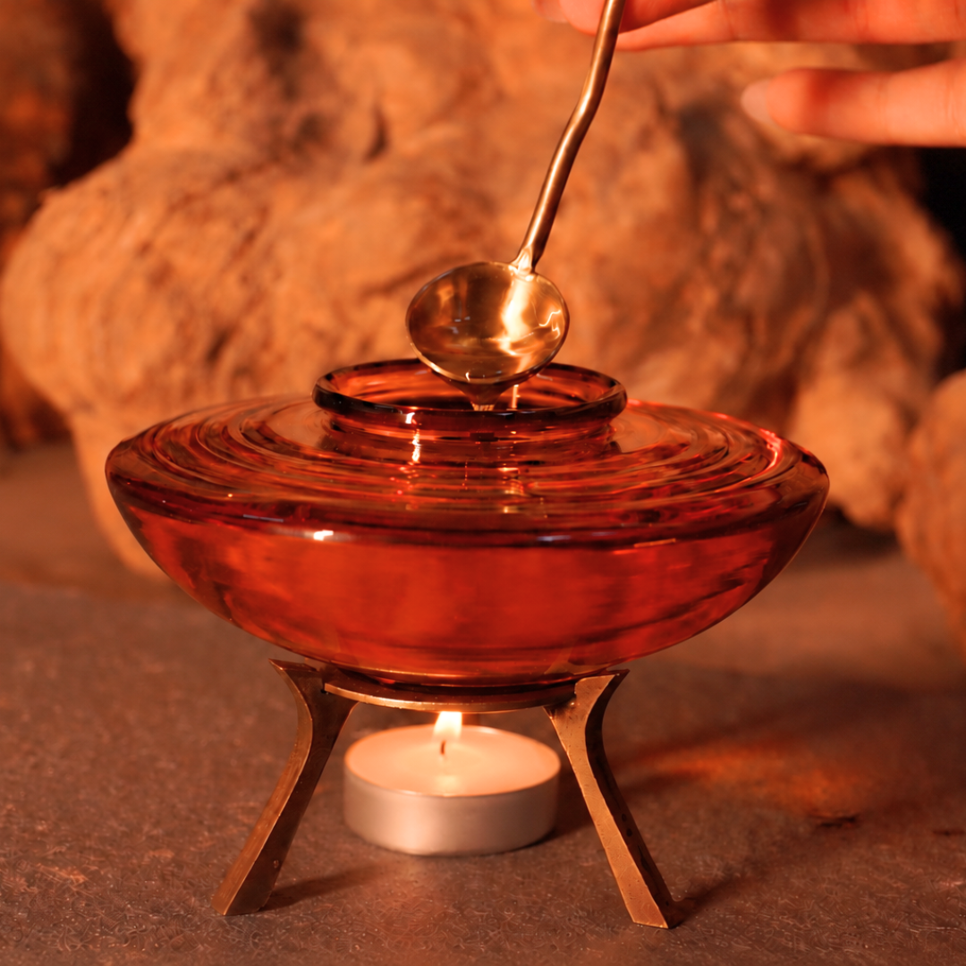 Ghee pot kept warm by a tealight beneath the stand