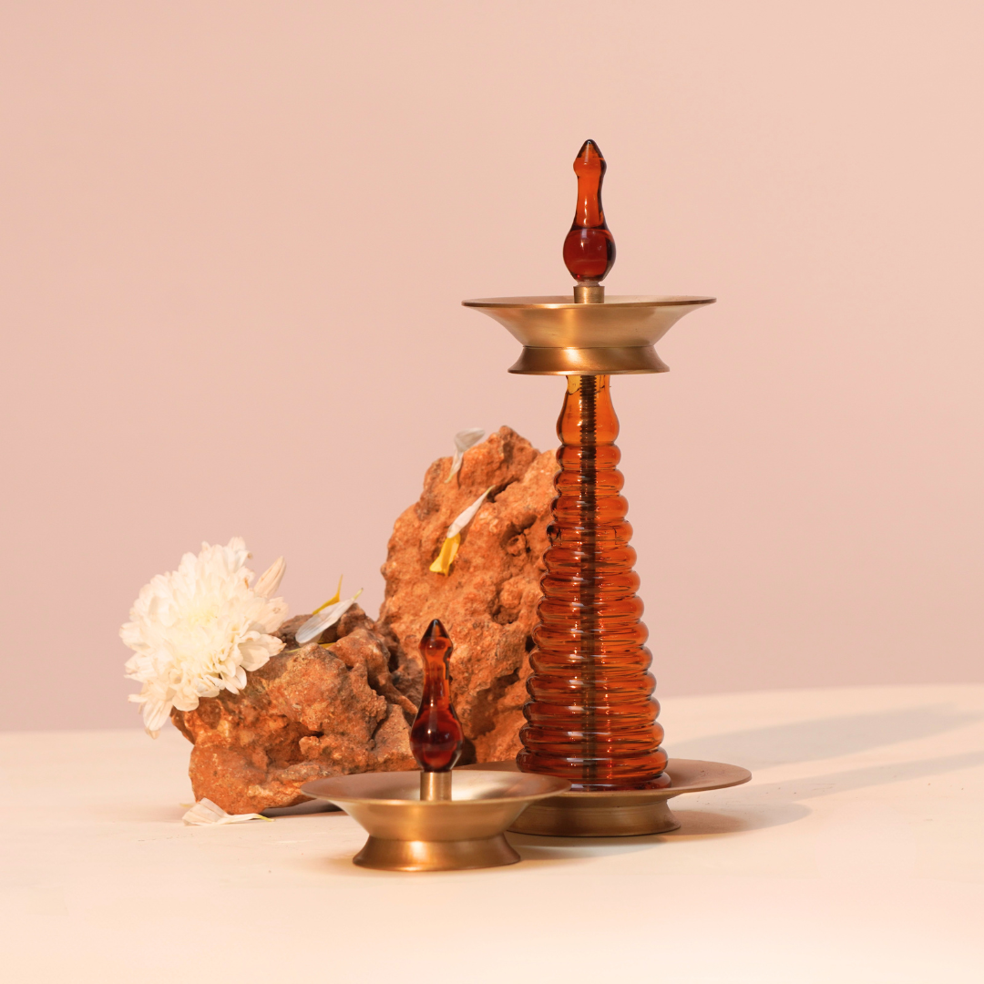 Tall and short brass and glass Nilavilakku lamps together