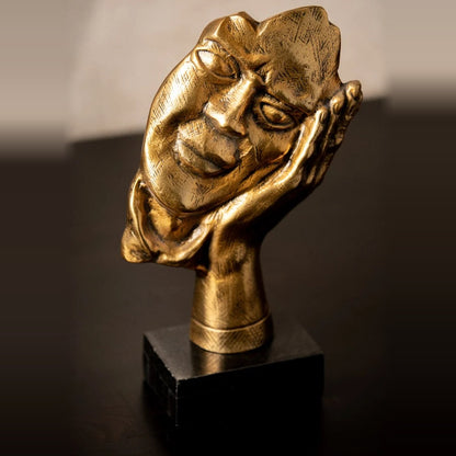 Resting John antique gold face sculpture on a marble base