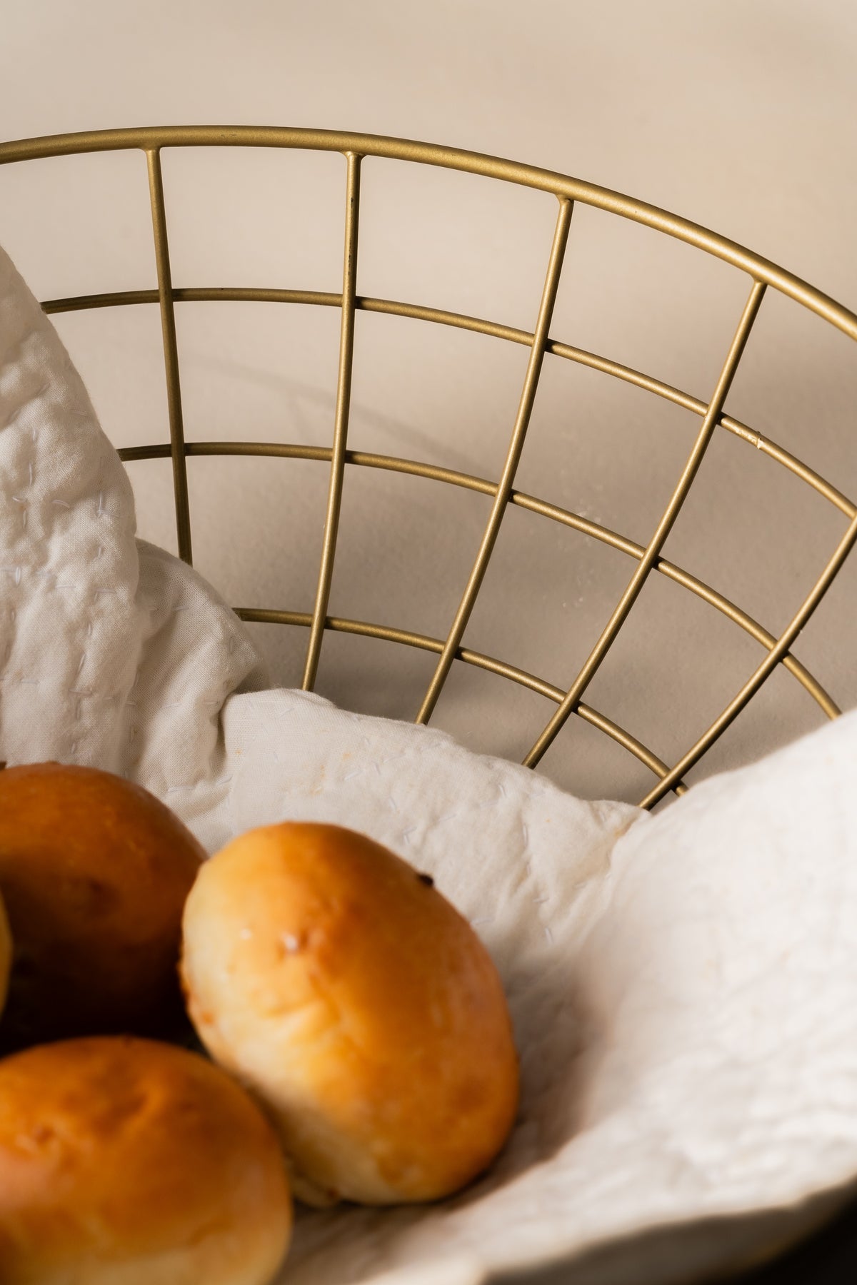 Bread rolls in a gold wire basket, close-up