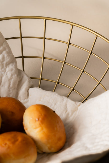 Bread rolls in a gold wire basket, close-up