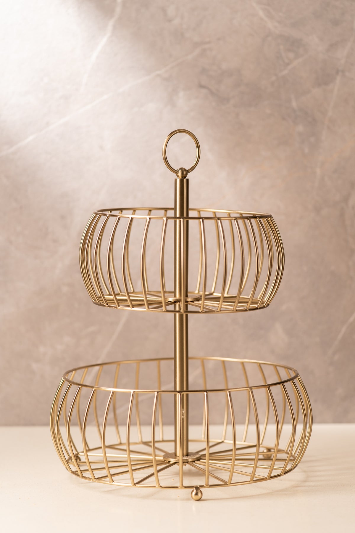 Tiered gold wire basket with looped handle, shown empty