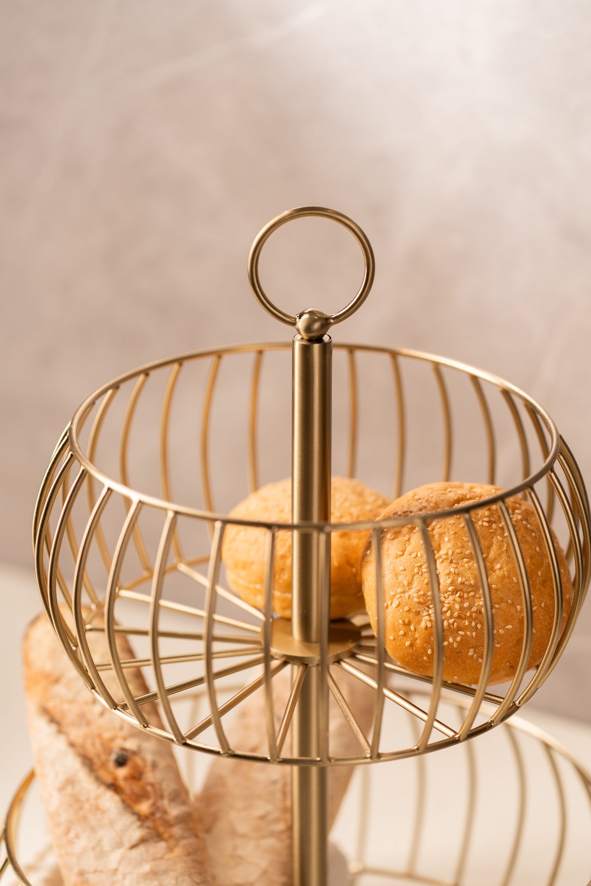 Close-up of the top tier and looped handle of the gold wire basket