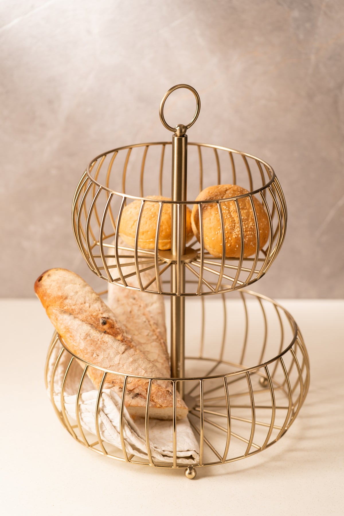 Gold wire fruit basket styled with bread on a kitchen counter