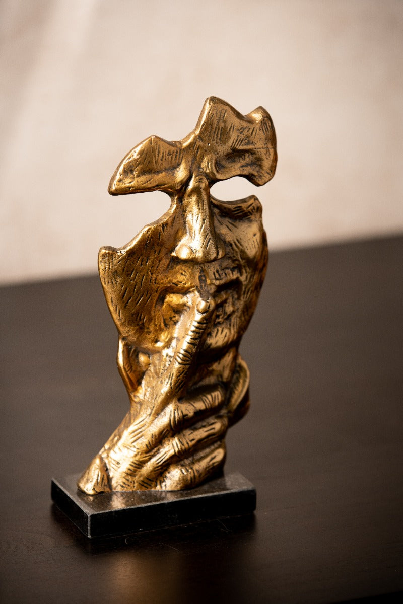 Abstract face sculpture with a finger to its lips