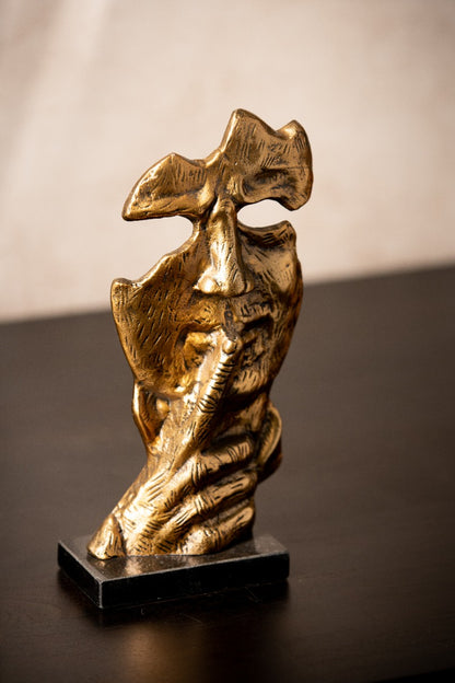 Abstract face sculpture with a finger to its lips