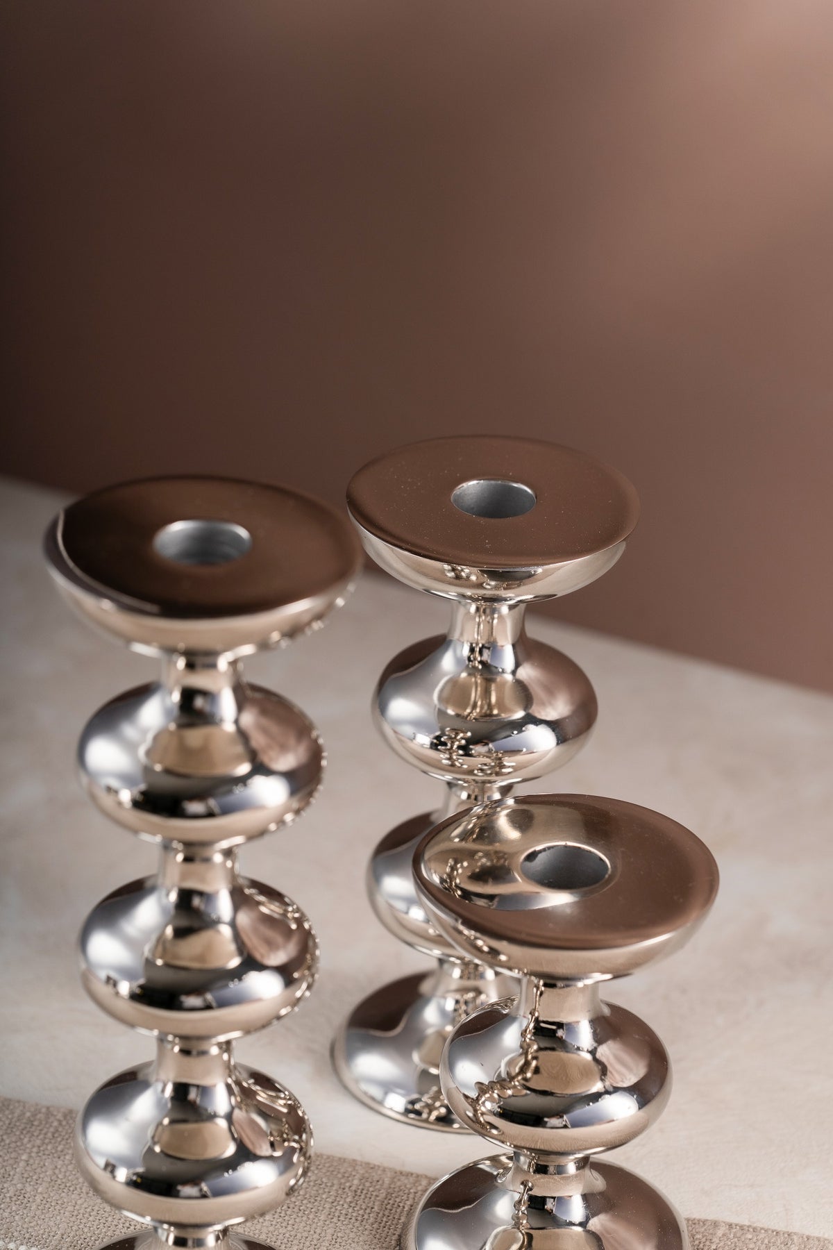 Silver candle holders styled on a table runner