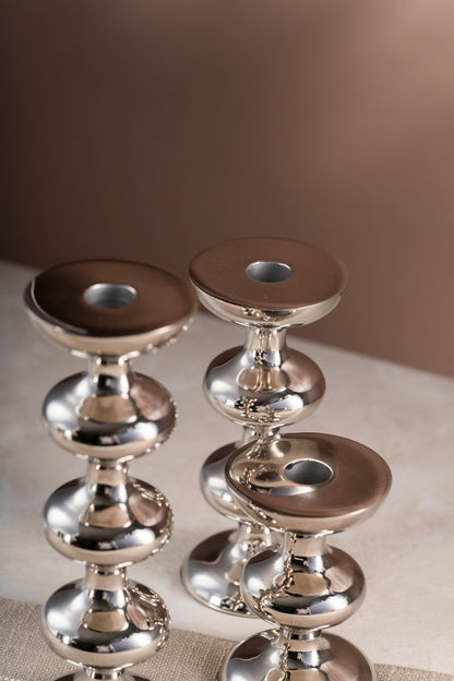 Silver candle holders styled on a table runner
