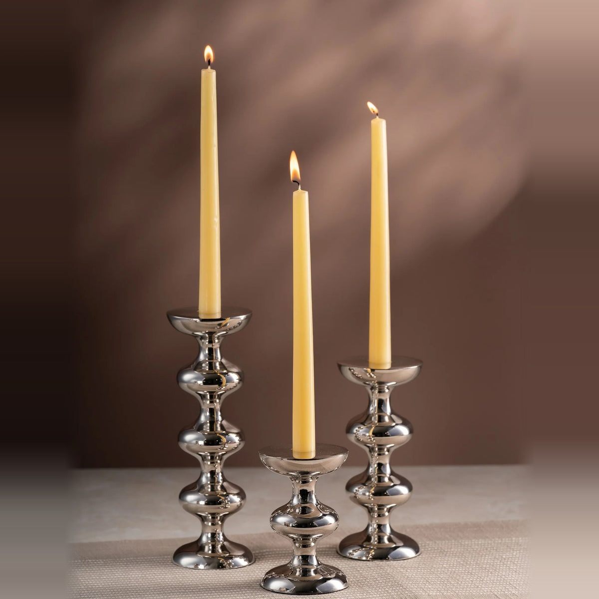 Three tiered silver candle holders with gold taper candles