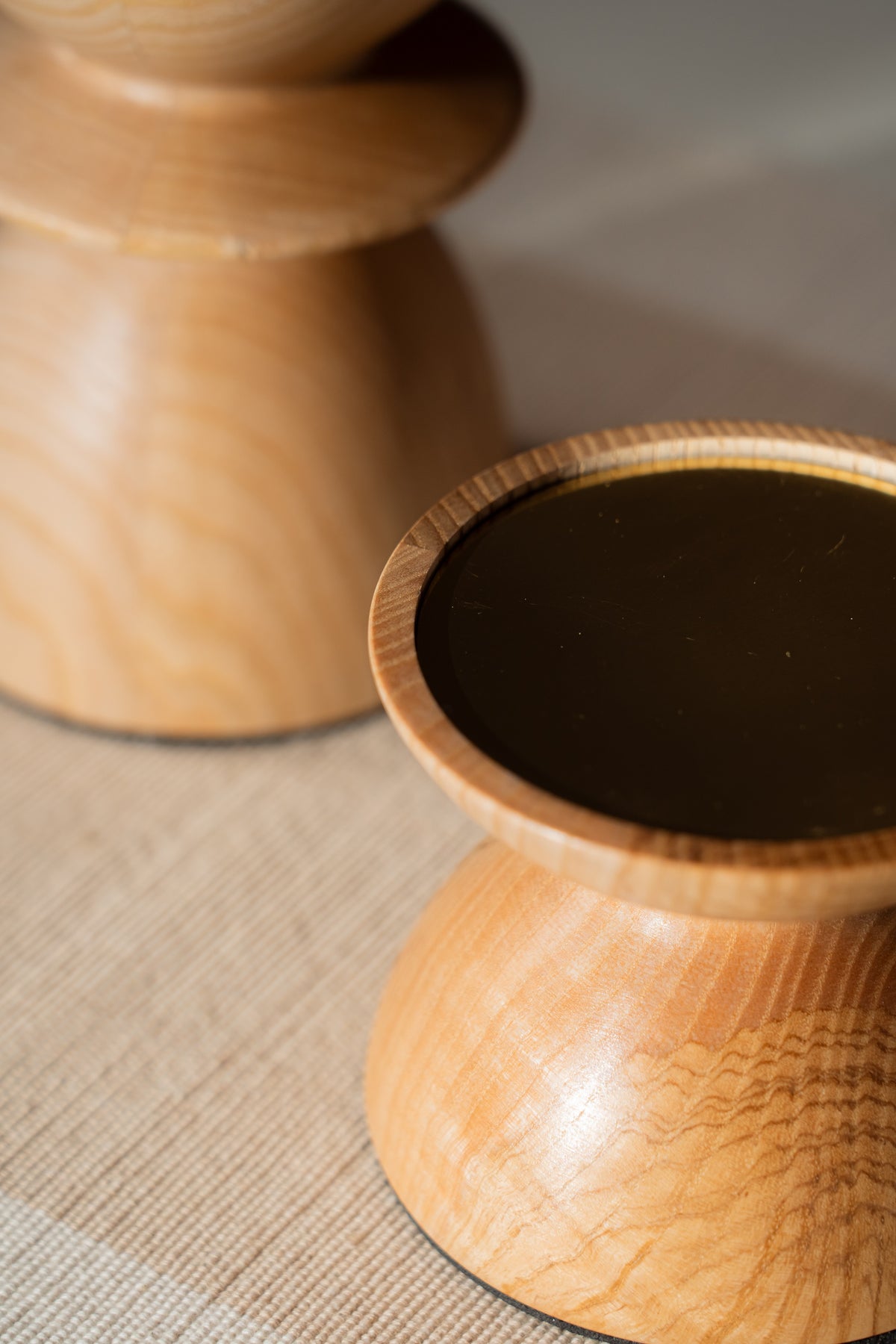 Two wooden pillar candle holders with lit pillar candles